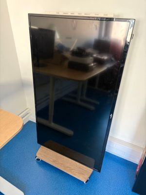 un téléviseur à écran plat posé sur un support dans le coin d'une pièce