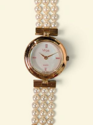 a close up of a wrist watch with pearls on it
