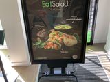 a sign that says eat salad on it in front of a window