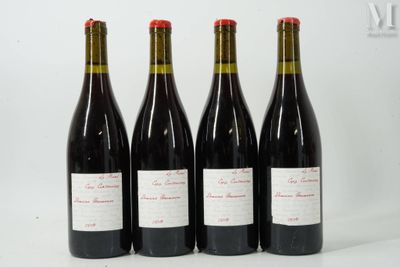 quatre bouteilles de vin sont alignées sur une surface blanche