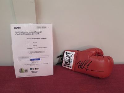 a red boxing glove sitting next to a certificate