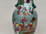 un vase avec un tableau posé sur une table