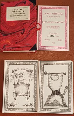 trois cartes sur lesquelles sont dessinés des chats et un chat assis sur une table