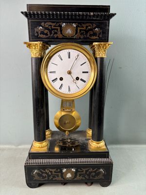 une horloge noire et or posée sur une table