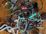 a pile of assorted jewelry on a wooden table