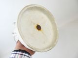 a person holding a white bowl with a brown substance on it