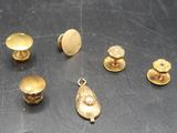 several pieces of gold metal on a table with a black background