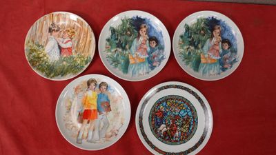 quatre assiettes sur lesquelles sont peints des enfants assis sur une nappe rouge