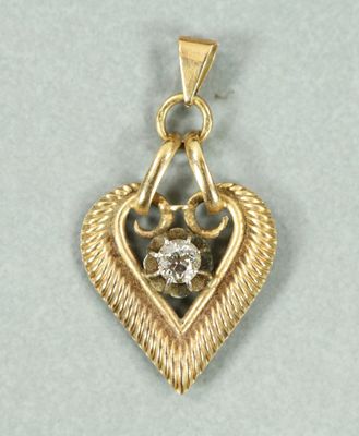 un gros plan d'un pendentif en forme de cœur orné d'un diamant au centre