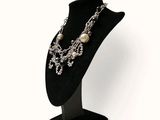 a mannequin with a necklace on it on a stand