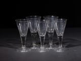 four empty wine glasses sitting on a table with a black background