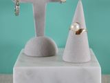 un gros plan sur une paire de boucles d'oreilles posées sur un socle en marbre