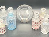 several glass bottles and a plate on a table with a silver plate