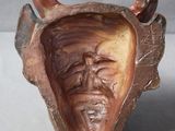 a clay sculpture of a man ' s face inside of a bowl