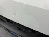 the front bumper of a white car with scratches on it