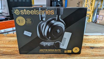 une boîte contenant des écouteurs SteelSeries posée sur une table en bois