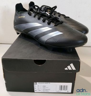 une boîte sur laquelle est posée une paire de chaussures de foot