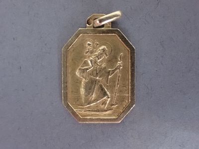 une médaille d'or sur laquelle figure le portrait d'un homme