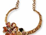 an image of a gold necklace with flowers on it