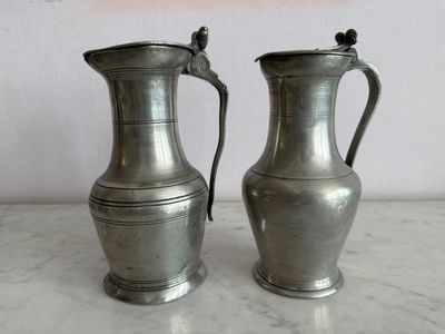 deux vases en argent posés sur une table en marbre