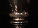 a close up of a silver cup sitting on top of a table