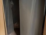 two trash cans that are sitting in the corner of a cabinet