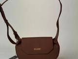 a close up of a brown purse on a white surface