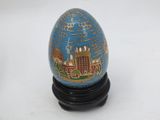 a blue egg with a picture of a city on it