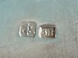 a pair of silver earrings that are sitting on a table