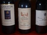 several bottles of wine are lined up on a red table