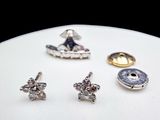 three pairs of silver and gold stud earrings on a white surface