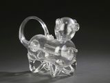figurine en cristal représentant un singe tenant une bouteille de vin sur fond noir