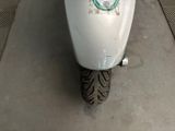 a white scooter with a sticker on the back of it