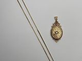 une image représentant un collier en or et un pendentif en or sur fond blanc
