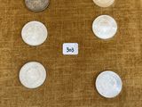 Plusieurs types de pièces de monnaie sont disposés en rangée sur une table