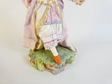 a figurine of a woman dressed in a purple dress