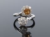 a close up of two rings with diamonds on a reflective surface