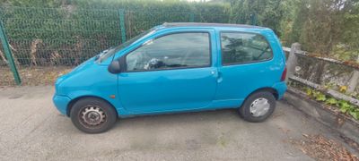 a small blue car parked on the side of the road