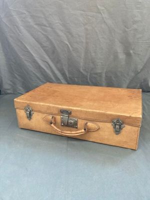 une vieille valise en bois posée sur un drap bleu