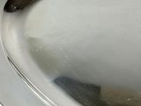 a silver plate with a silver handle on a table