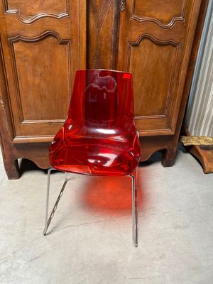 une chaise rouge posée devant une armoire