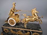 a statue of a man riding on a horse drawn carriage