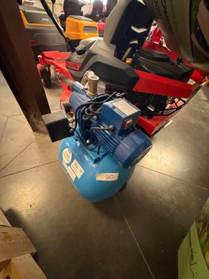 un compresseur d'air bleu posé sur une table dans une pièce