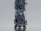 La statue d'un ange tenant une croix se trouve sur un socle