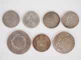 six different british coins are shown in a row on a white surface