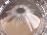 a close up view of a glass of water with a flower in it
