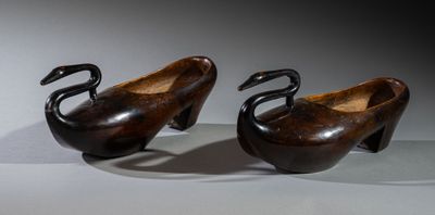 pair of carved wooden swan bowls on stand on white surface