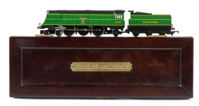 a green and black train engine on a wooden stand