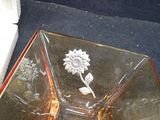 a glass bowl with a flower on it sitting on a table