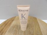 a close up of a tube of kerastasee glosse about on a wooden table